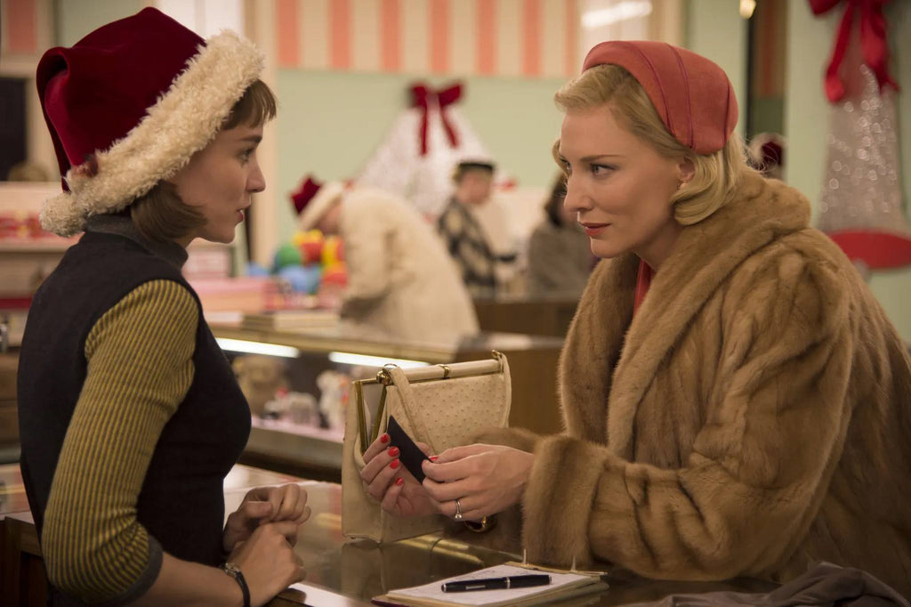 Screen from the movie Carol. Two women talking over a counter during the Christmas holidays.